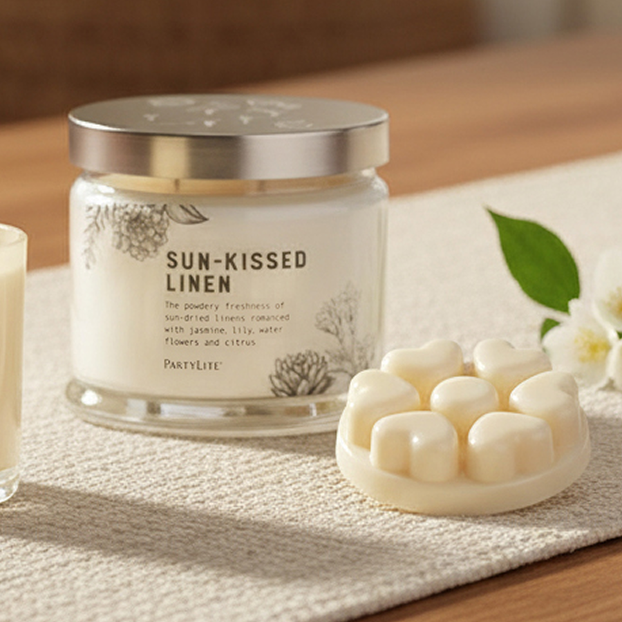 Sun-Kissed Linen 3-wick, melt and Escential Jar with white flowers on a wooden table with table runner