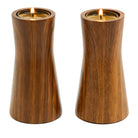 A pair of faux bois tealight holders with lit candles inside, mimicking a wood grain appearance.