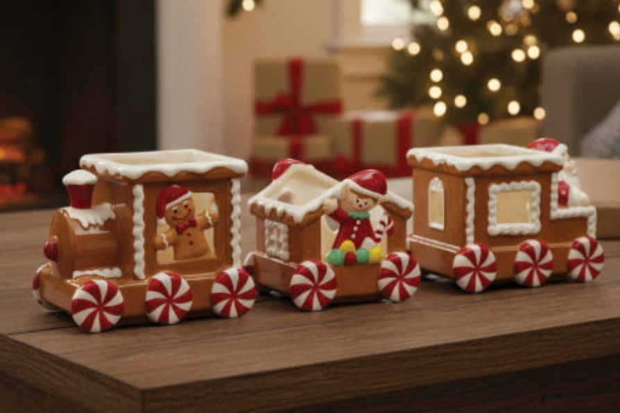 Decorative gingerbread train on a wooden surface with Christmas decorations in the background.