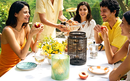 Geometric Hurricane and Tropical Palm Hurricane displayed on a table outdoors with smiling people and a bowl of food being served