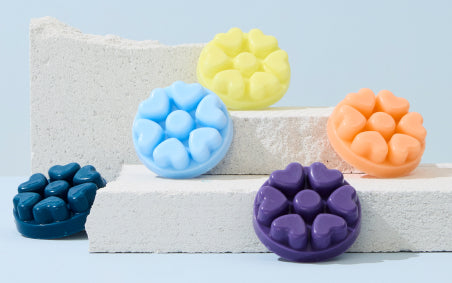 Five various melts displayed on or against large flat stones