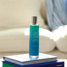 Calm Room Spray from the Mood Collection standing on books with a light blurred background.