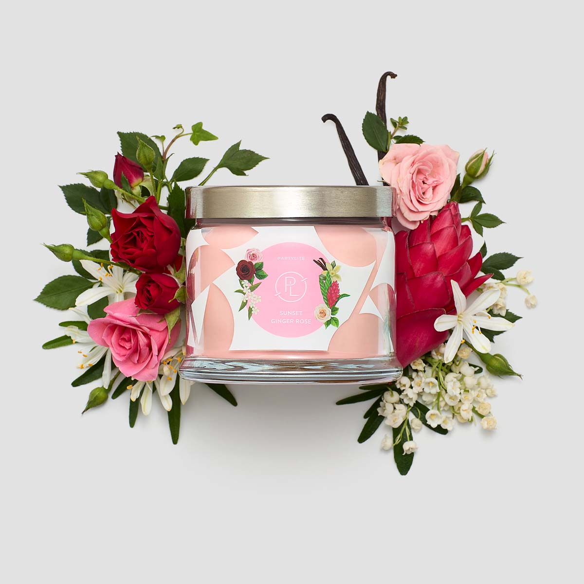 Sunset Ginger Rose 3-Wick Jar Candle surrounded by flowers against a white background.