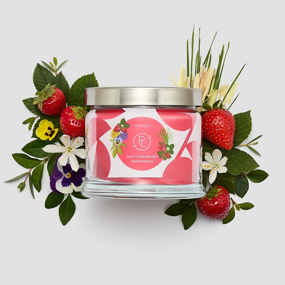 Juicy Strawberry Lemongrass 3-wick Jar Candle shown with Strawberries and flowers against a white background.