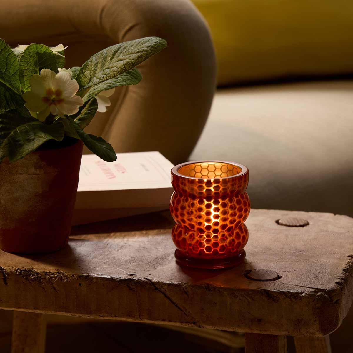 Honeycomb Tealight/ Votive Holder with a lit candle with a plant pot next to it.