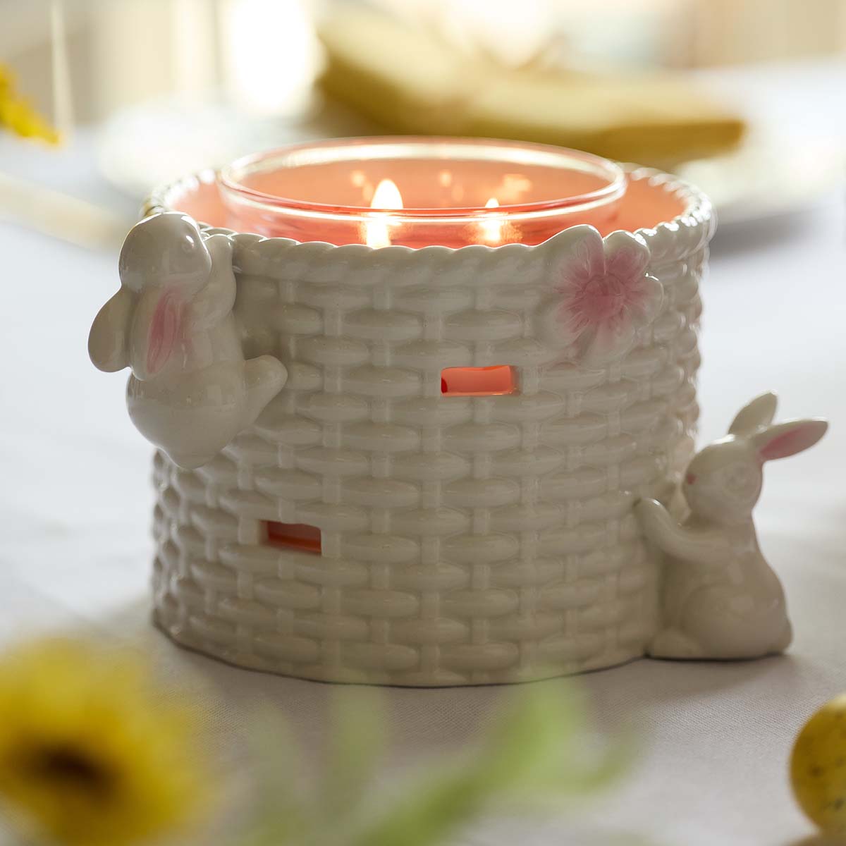 Easter Basket Candle Holder with Bunny Rabbits shown with a lit 3-wick jar candle.