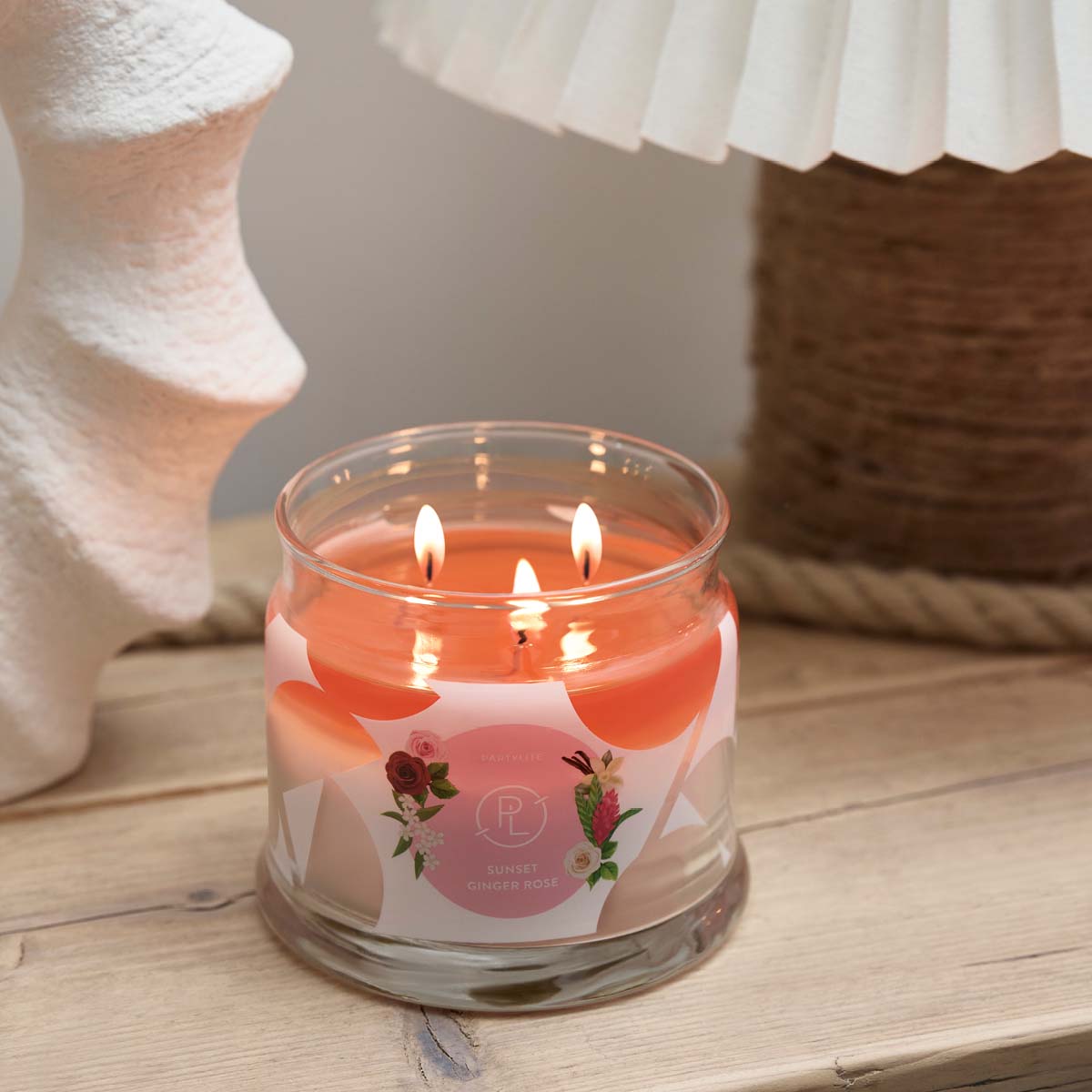 Sunset Ginger Rose 3-Wick Jar Candle on a wooden surface.