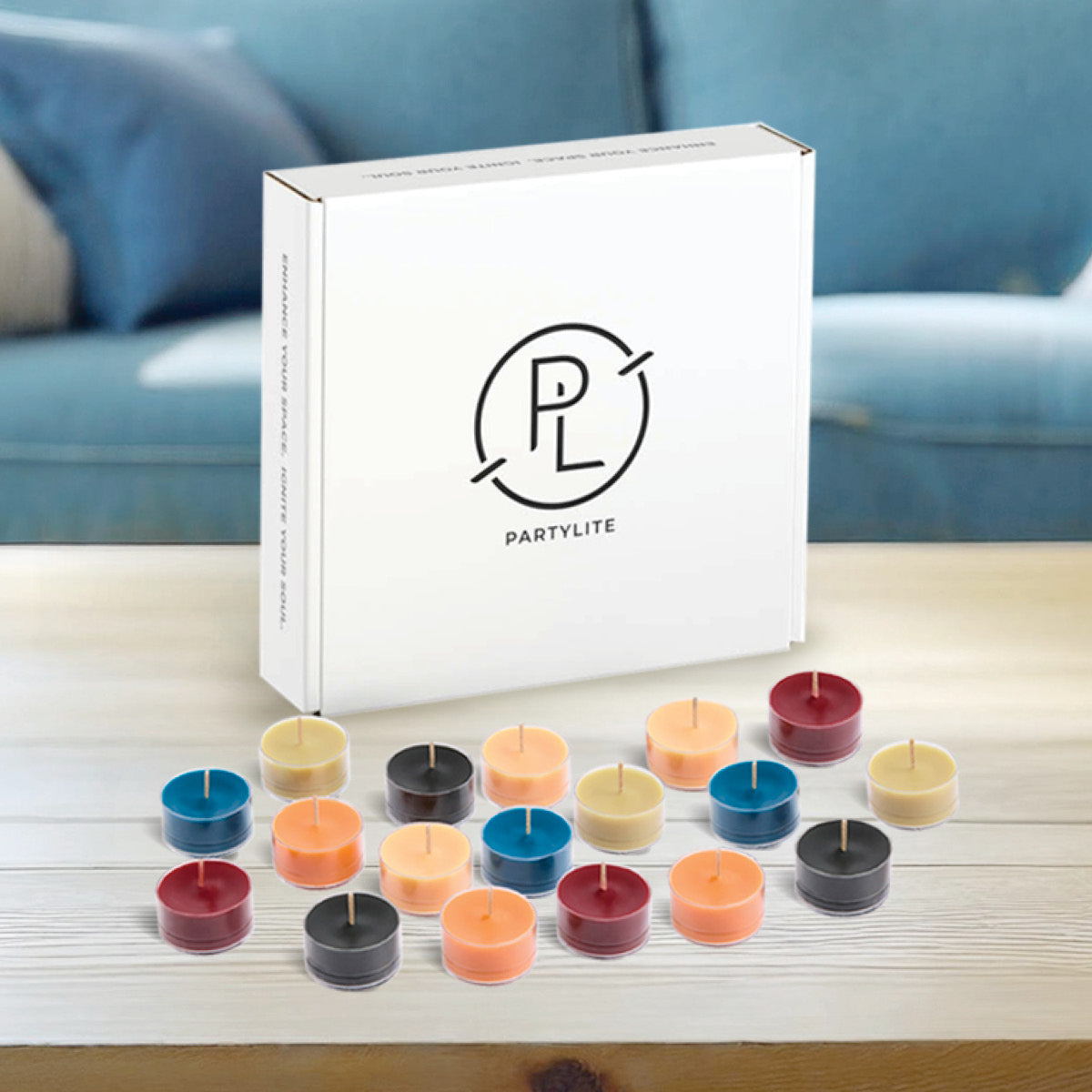 Multiple tealights from the Mood 50-Piece tealight sampler displayed in front of the tealight box with the PL logo in a living room setting