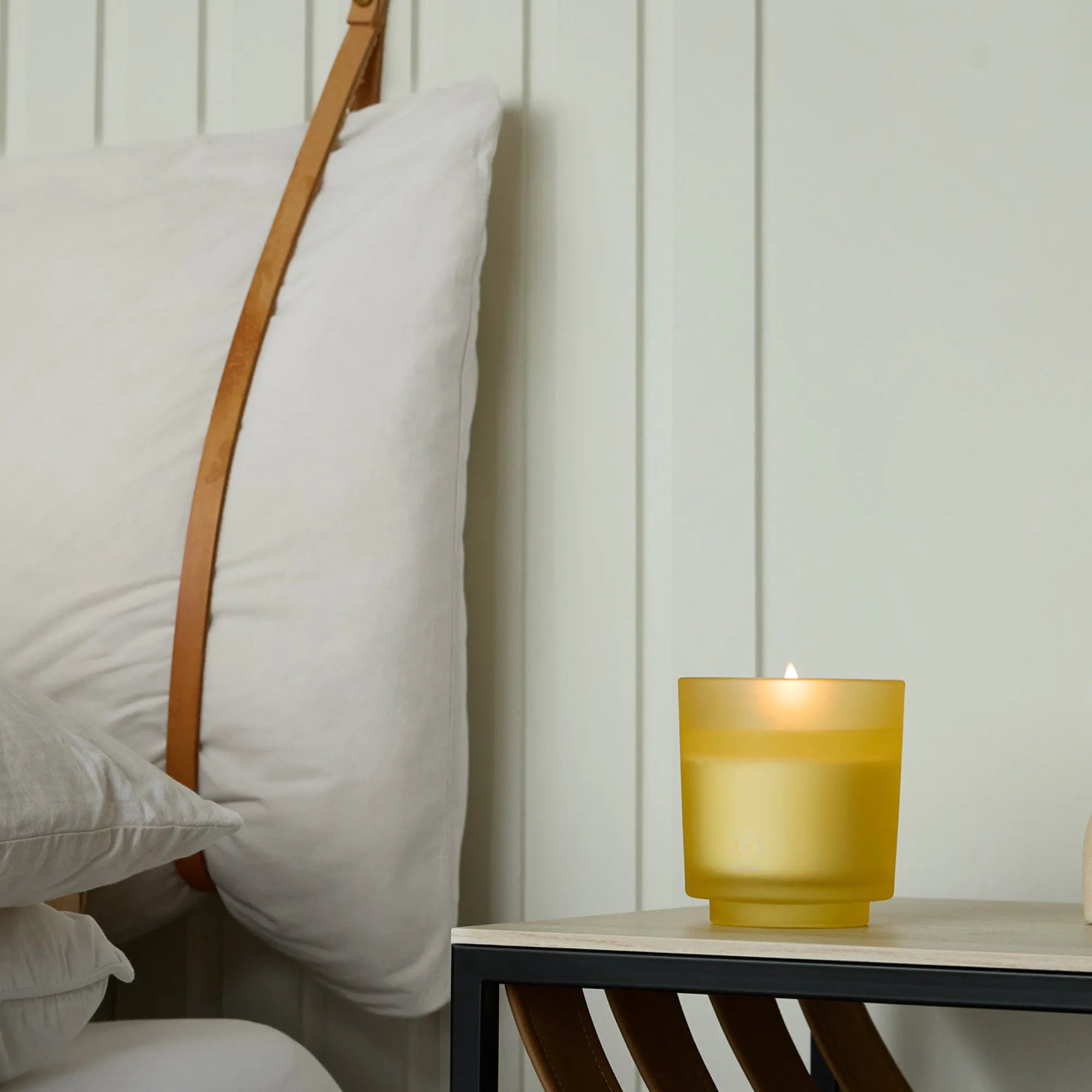 Coastal Amber & Shea Refillable Jar Candle on a bedside table against a light background