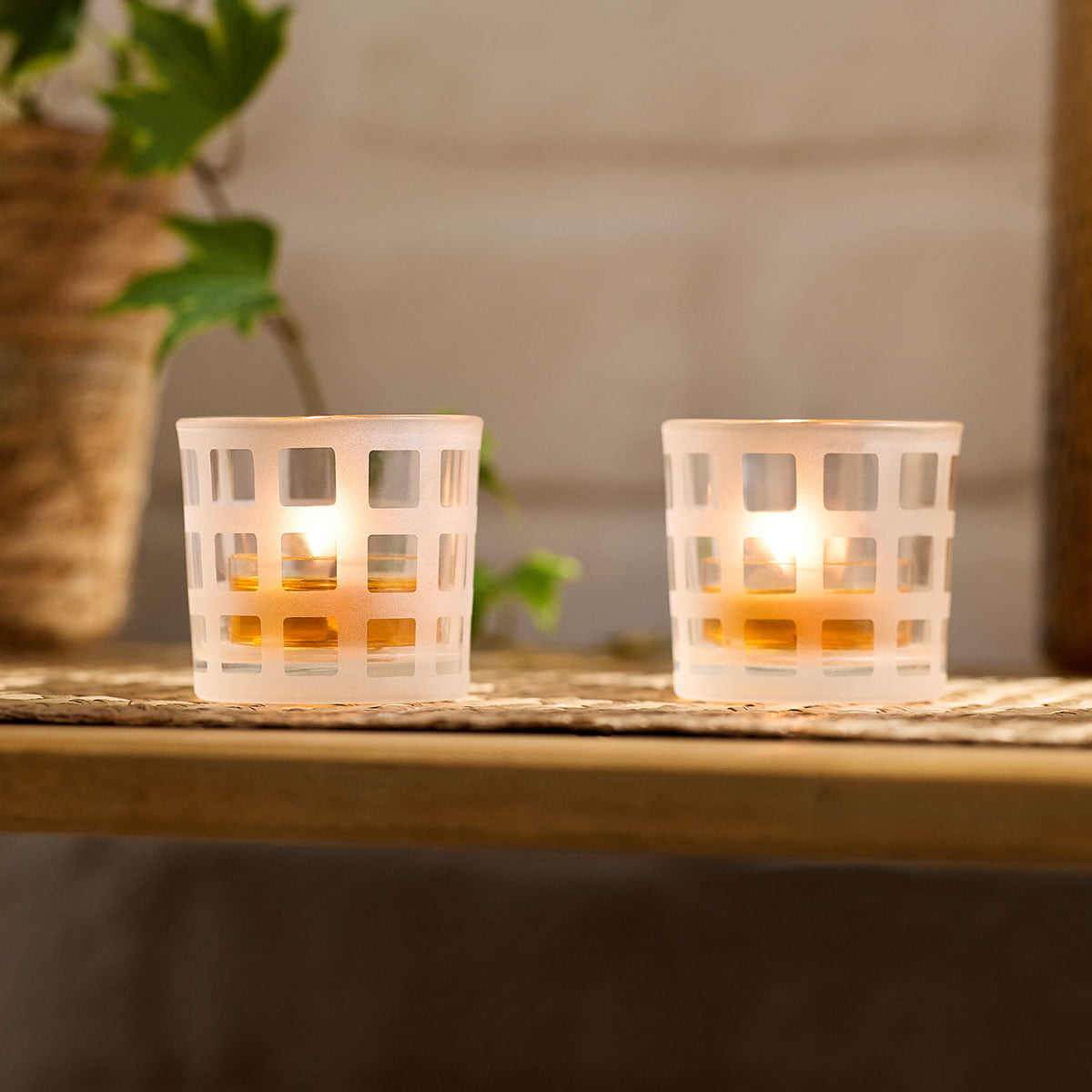 Hip-to-Be-Square Tealight/Votive Holder Pair shown on a woven table mat on a wooden table with a light background