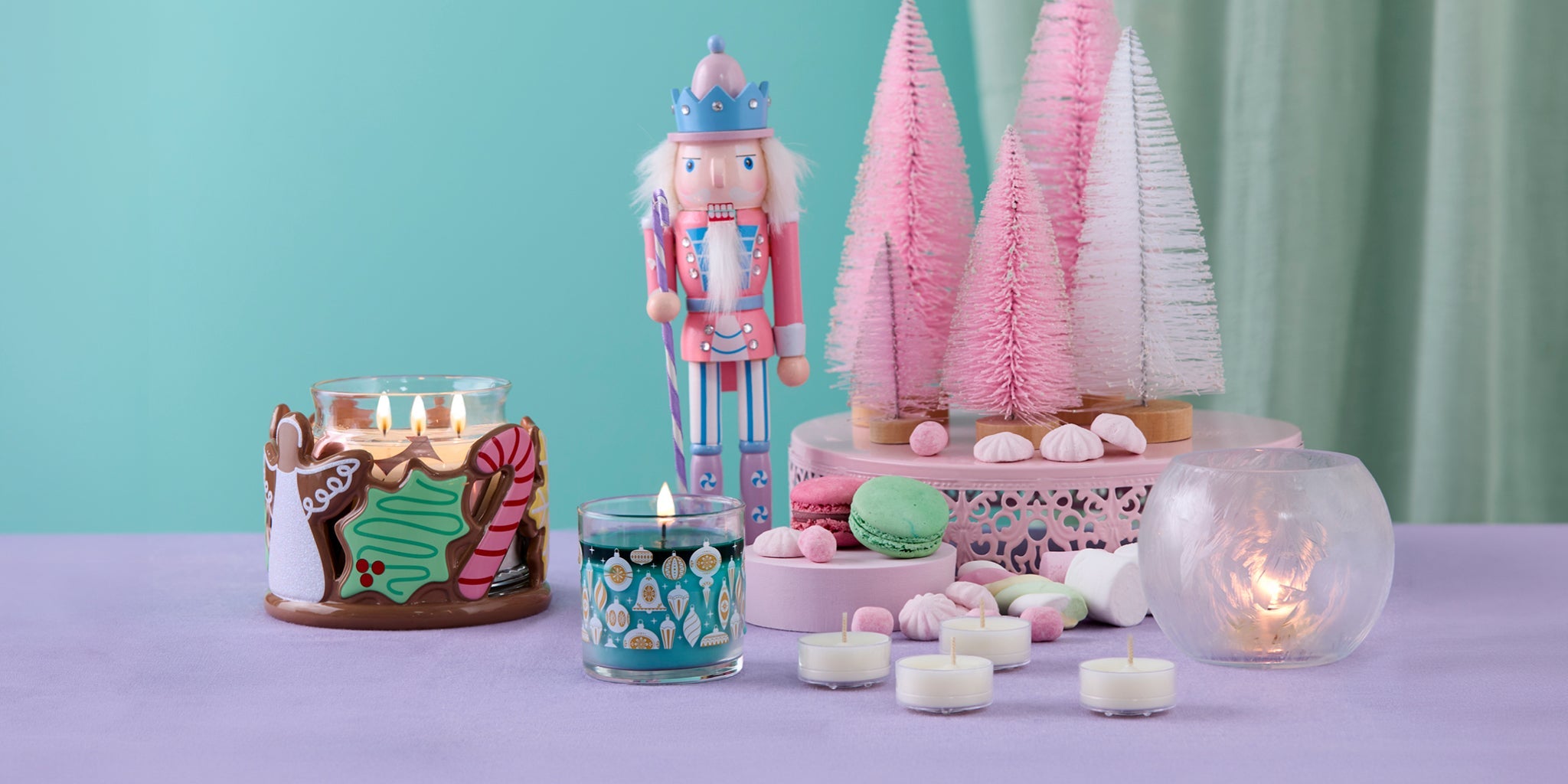 Christmas Cookie jar holder along with a mini jar candle a decorative nutcracker and some tealights on a table
