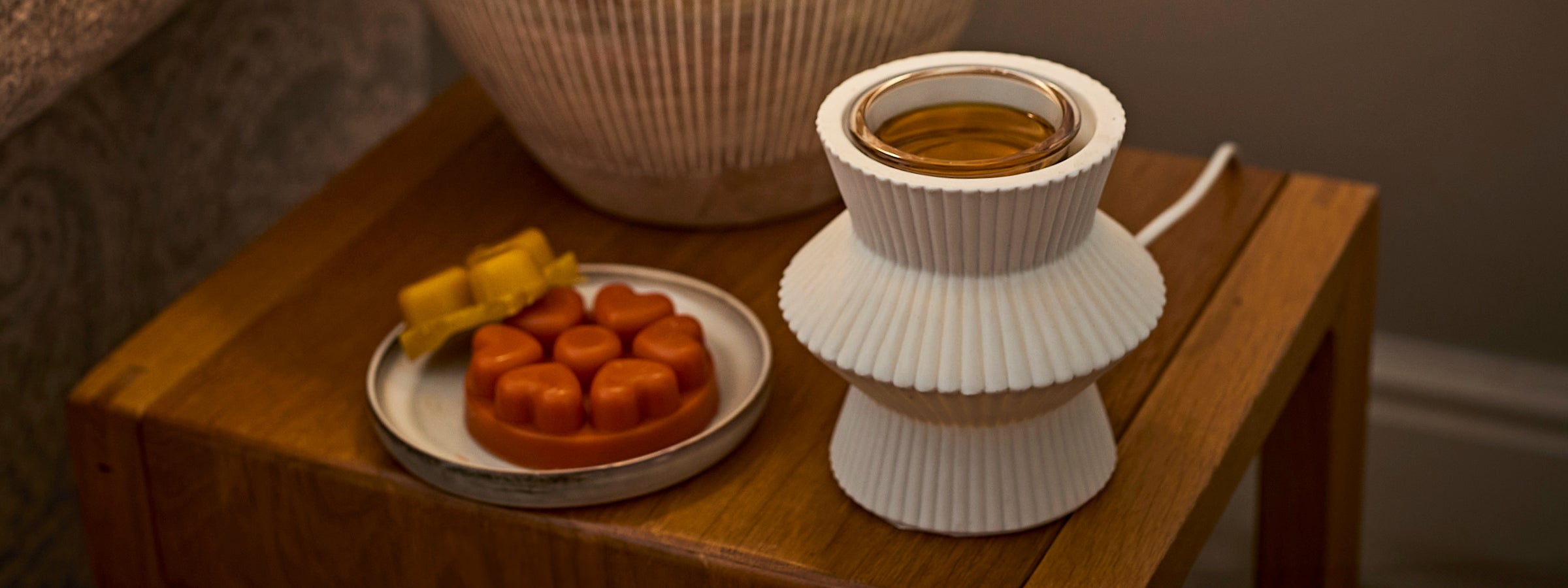 White wax melt warmer with wax melts on a side table