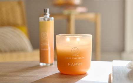 PL Happy Ombre Jar Candle and Happy Room Spray from the Mood collection on a wood table