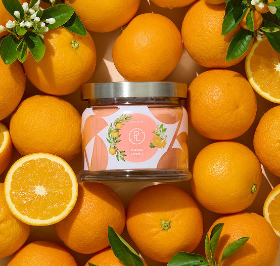 Seaside Neroli 3-Wick jar candle, with decorated label featuring oranges and blossoms with oranges surrounding. 